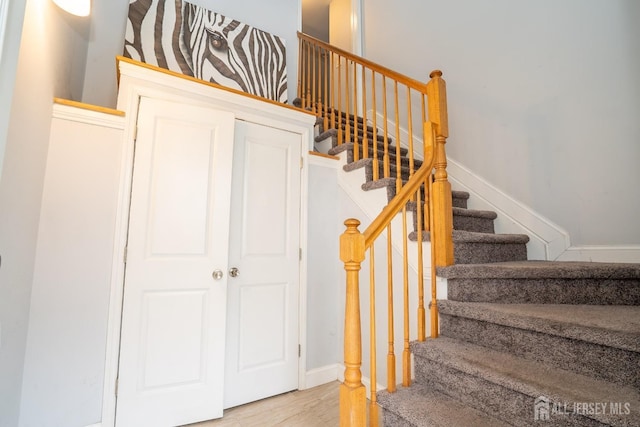 stairs with wood finished floors and baseboards