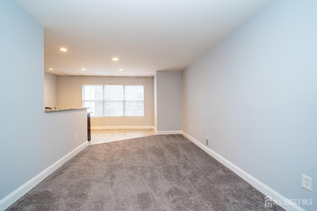 carpeted spare room featuring recessed lighting, visible vents, and baseboards