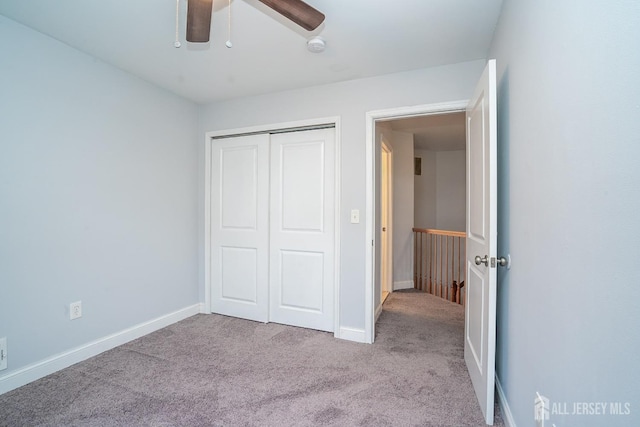 unfurnished bedroom featuring ceiling fan, a closet, and light carpet