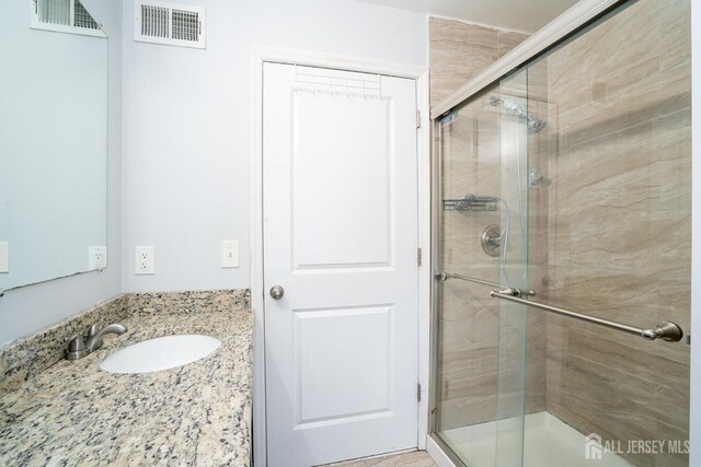 bathroom with sink and an enclosed shower