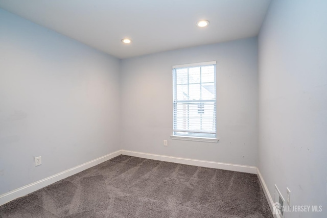 spare room featuring visible vents, baseboards, dark colored carpet, and recessed lighting