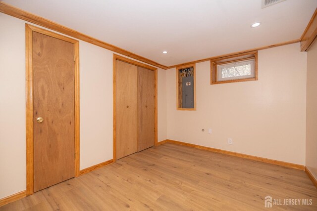 unfurnished bedroom featuring ornamental molding, electric panel, and light hardwood / wood-style floors