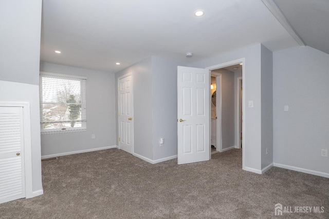 unfurnished bedroom featuring lofted ceiling and carpet