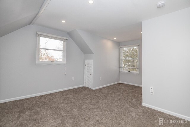 additional living space featuring lofted ceiling and carpet floors