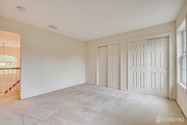 15 Fabiszewski Way, Parlin, NJ 08859 - unfurnished bedroom featuring multiple closets, carpet flooring, a chandelier, and baseboards