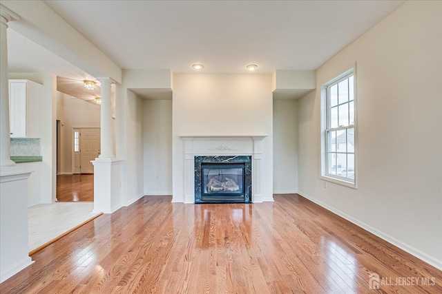 15 Fabiszewski Way, Parlin, NJ 08859 - unfurnished living room with decorative columns, light wood-style floors, a fireplace, and baseboards
