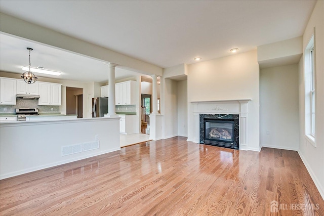 15 Fabiszewski Way, Parlin, NJ 08859 - unfurnished living room featuring light wood finished floors, a premium fireplace, ornate columns, recessed lighting, and baseboards