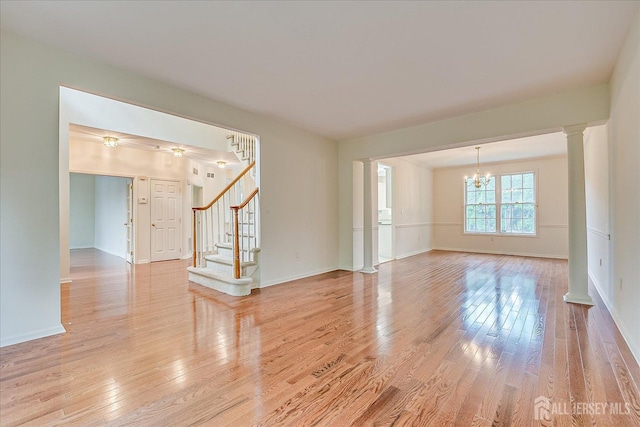15 Fabiszewski Way, Parlin, NJ 08859 - unfurnished room with a chandelier, light wood-style flooring, stairway, baseboards, and decorative columns