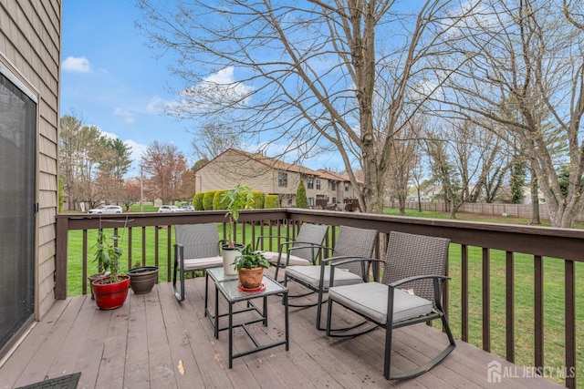 wooden terrace featuring a residential view and a yard