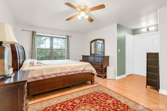 bedroom featuring ceiling fan, light wood-style flooring, and baseboards
