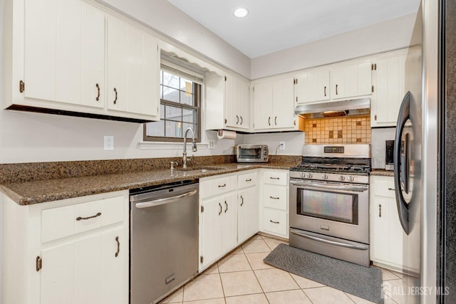 kitchen with recessed lighting, a sink, stainless steel appliances, under cabinet range hood, and white cabinets