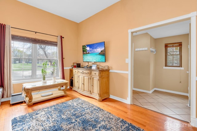 sitting room with baseboards and light wood-style flooring