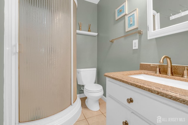 bathroom featuring a shower, toilet, vanity, and tile patterned flooring