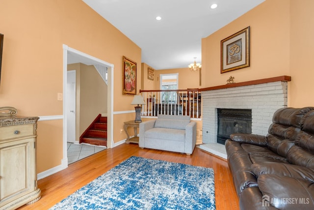 living area with stairway, a chandelier, baseboards, recessed lighting, and wood finished floors