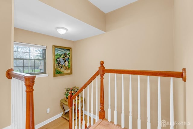 stairway featuring baseboards and wood finished floors