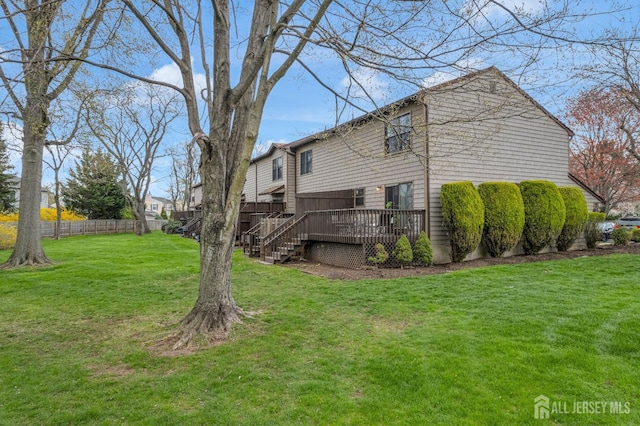 back of house featuring fence, a yard, stairs, and a wooden deck