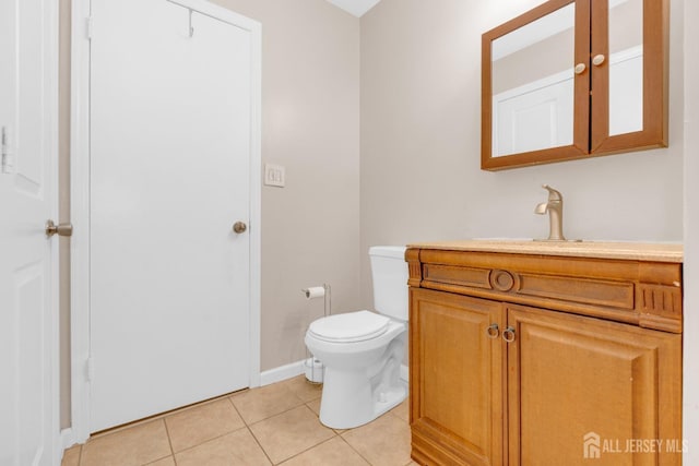 bathroom featuring toilet, vanity, tile patterned floors, and baseboards