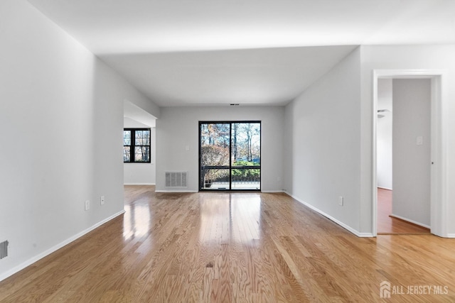 empty room featuring baseboards, visible vents, and light wood-style floors