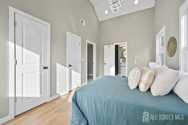 15 Clausen Ln, Sayreville, NJ 08872 - bedroom with high vaulted ceiling, light wood finished floors, and ensuite bath