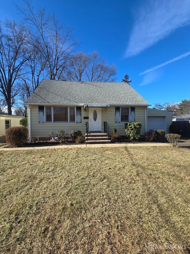 single story home with a garage, a shingled roof, and a front lawn