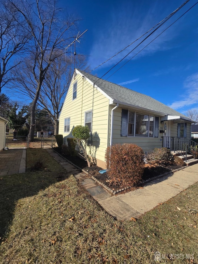 view of side of property featuring roof with shingles