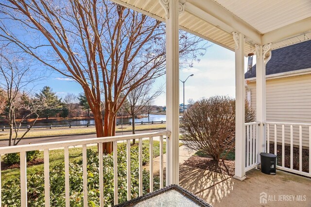 balcony featuring a porch and a water view