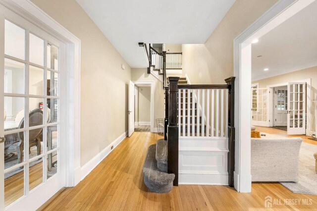 hall featuring light hardwood / wood-style floors and french doors