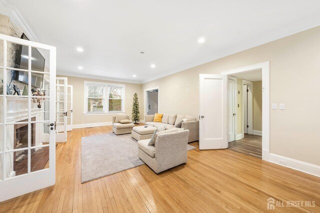 living room with french doors, light hardwood / wood-style flooring, and ornamental molding