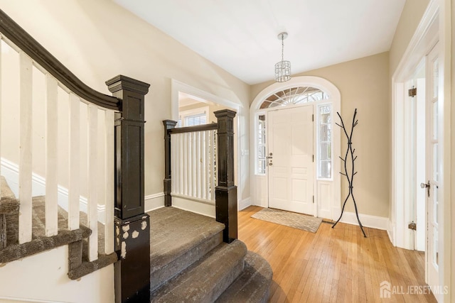 entryway featuring a chandelier, plenty of natural light, and wood-type flooring