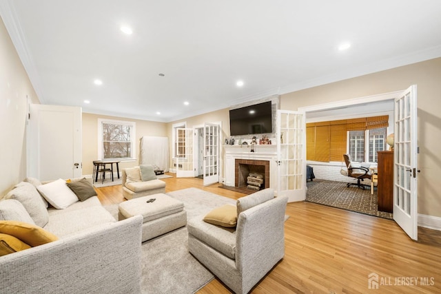 living room featuring ornamental molding, light hardwood / wood-style flooring, plenty of natural light, and french doors