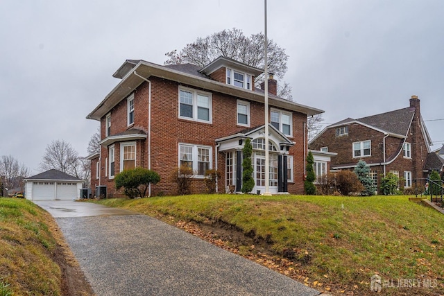 view of front of home with a garage, central air condition unit, a front yard, and an outdoor structure