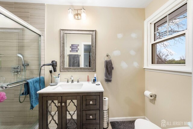 bathroom with vanity, toilet, and an enclosed shower