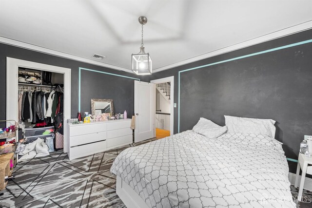 bedroom featuring crown molding and a closet