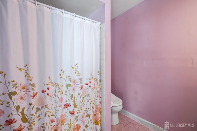 bathroom with a shower with shower curtain, tile patterned floors, toilet, and baseboards