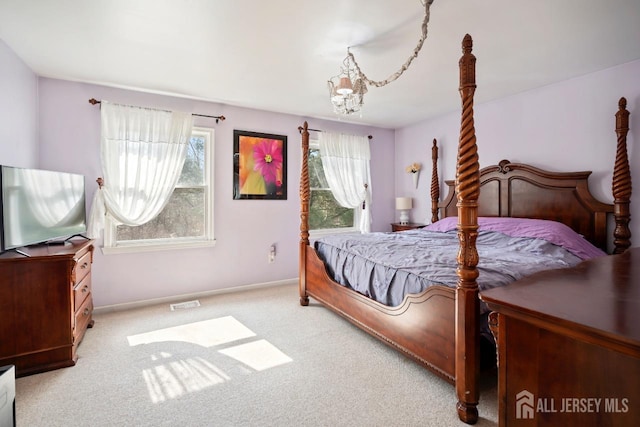 carpeted bedroom with a chandelier and baseboards