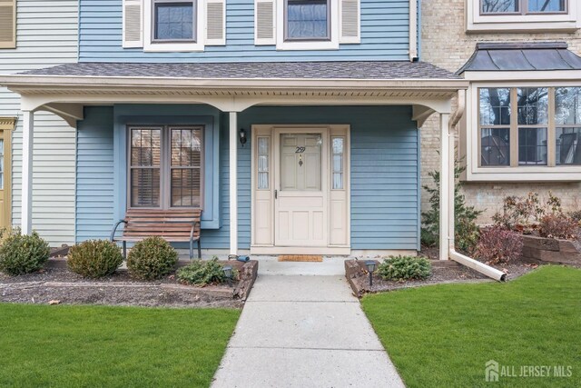 entrance to property featuring a lawn and a porch