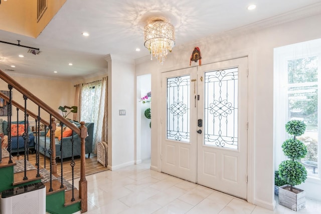 entryway featuring an inviting chandelier, a healthy amount of sunlight, and crown molding