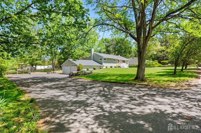 13 Orchard Pkwy, Morganville, NJ 07751 - view of front of property with asphalt driveway, a garage, and a front yard