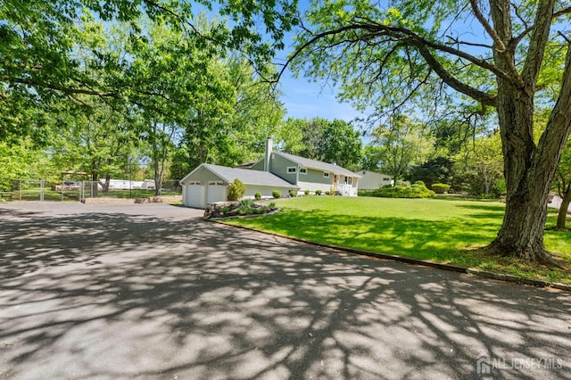 13 Orchard Pkwy, Morganville, NJ 07751 - view of front of house with asphalt driveway, a garage, and view of wooded area