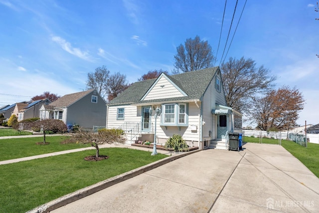 750 Barry Ave, Perth Amboy, NJ 08861 - bungalow-style house featuring fence, a front lawn, concrete driveway, and roof with shingles