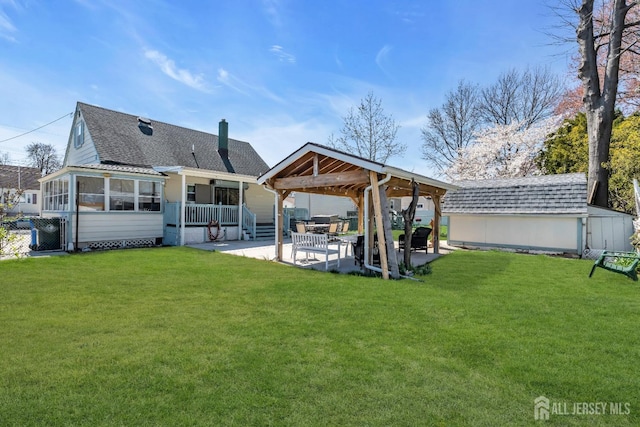 750 Barry Ave, Perth Amboy, NJ 08861 - back of property featuring a lawn, a shingled roof, a sunroom, and a patio area