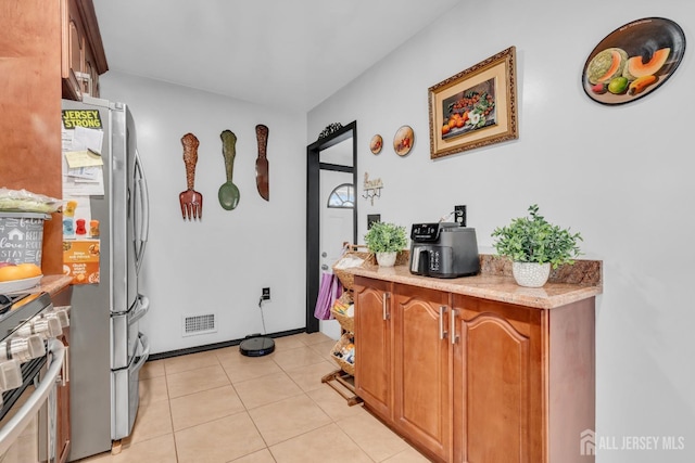 750 Barry Ave, Perth Amboy, NJ 08861 - kitchen with brown cabinets, visible vents, stainless steel appliances, and light tile patterned floors