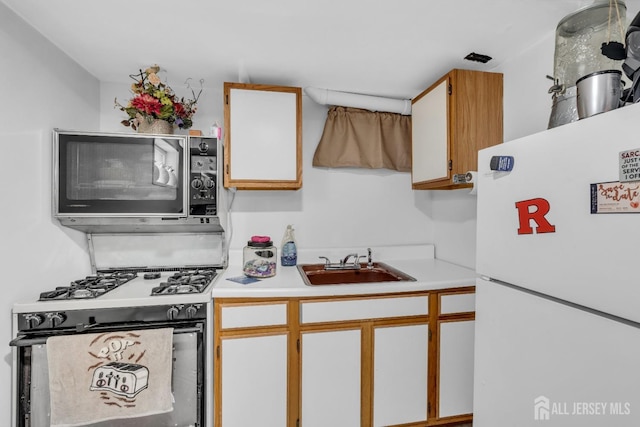 750 Barry Ave, Perth Amboy, NJ 08861 - kitchen with range with gas cooktop, freestanding refrigerator, light countertops, and a sink