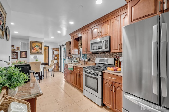 750 Barry Ave, Perth Amboy, NJ 08861 - kitchen with decorative backsplash, light tile patterned floors, appliances with stainless steel finishes, light stone countertops, and recessed lighting