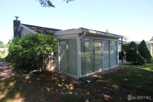 236-A Vernon Rd, Monroe, NJ 08831 - view of home's exterior with a sunroom and a chimney