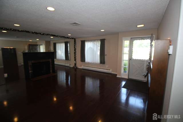 236-A Vernon Rd, Monroe, NJ 08831 - unfurnished living room with baseboard heating, a textured ceiling, dark wood-style flooring, recessed lighting, and a fireplace