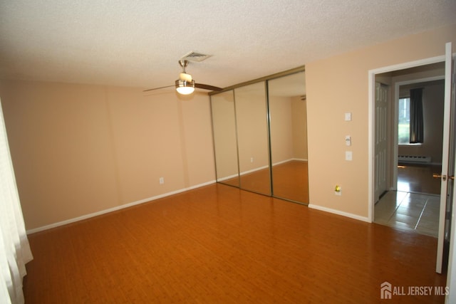 236-A Vernon Rd, Monroe, NJ 08831 - unfurnished bedroom with a baseboard radiator, a ceiling fan, and a textured ceiling