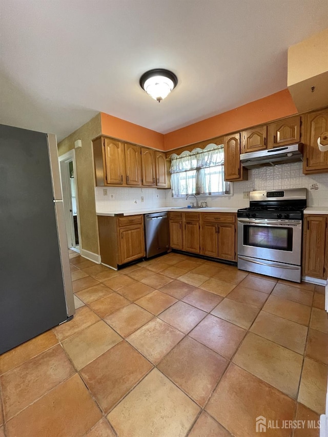 1211 S 9th St, South Plainfield, NJ 07080 - kitchen with appliances with stainless steel finishes, under cabinet range hood, a sink, and decorative backsplash