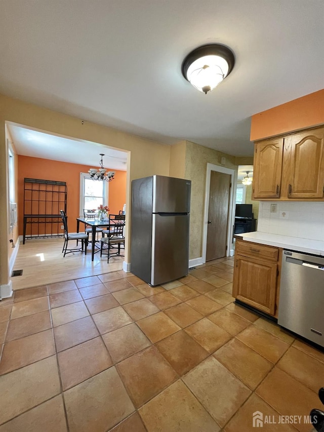 1211 S 9th St, South Plainfield, NJ 07080 - kitchen featuring stainless steel appliances, light countertops, a chandelier, light tile patterned floors, and baseboards