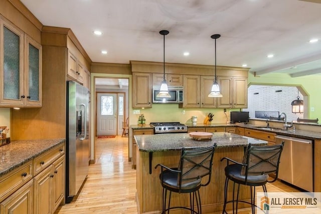 57 Jensen St, East Brunswick, NJ 08816 - kitchen with appliances with stainless steel finishes, light wood finished floors, a breakfast bar area, dark stone countertops, and recessed lighting